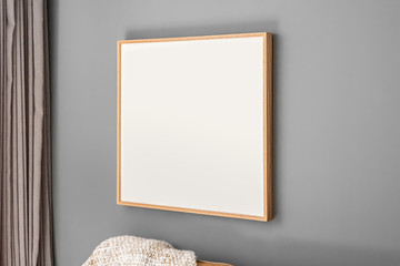 Interior decoration, empty wooden square frame, poster white canvas mock up on a gray wall, living...
