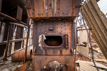 An old furnace sits in the middle of the remnants of an airplane hanger. Military base in Greenland. 