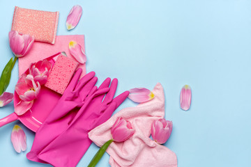 Set of cleaning supplies and spring flowers on color background