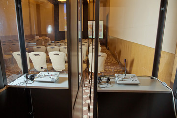 Soft focus of wireless Conference microphones and notebook in a meeting room. translators cubicle ....