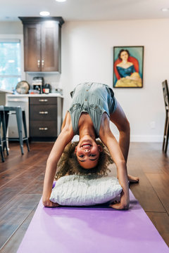 Girl doing backbend in living room of home