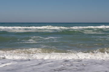 Sea, sea waves and shoreline on a sunny windy day.