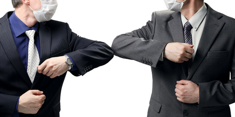 Two businessmen in suits greet each other without a handshake