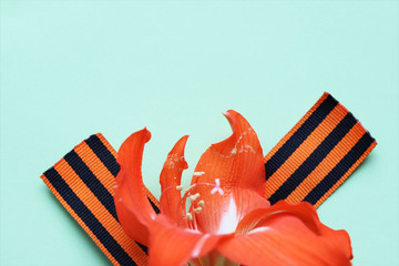 Ribbon of St. George and orange lily flower on the background for Victory Day. May 9, 2020 - 75...