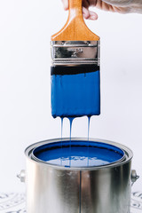 Blue paint can with brush