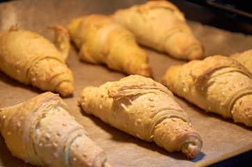 Baking croissants in the oven - close-up of the growth of pastry