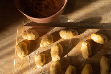 Potato pies with cabbage before baking on a cutting board. © Виктор Кеталь