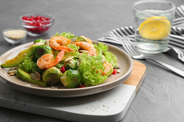 Tasty salad with Brussels sprouts served on grey table