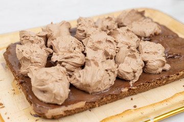 Chocolate cream on the cake. Preparing chocolate cake