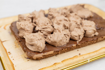 Chocolate cream on the cake. Preparing chocolate cake