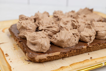 Chocolate cream on the cake. Preparing chocolate cake