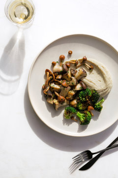 Overhead view of mushrooms and broccoli with cream dip served on plate