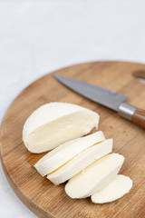 Fototapeta na wymiar Sliced Mozarella cheese on the round wooden board