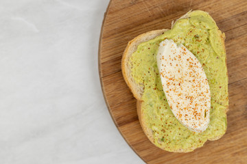 Sliced mozarella on the avocado spread toast