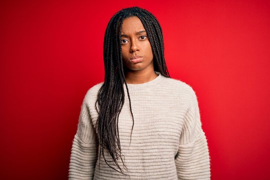 Young african american woman wearing casual winter sweater over red isolated background depressed and worry for distress, crying angry and afraid. Sad expression.