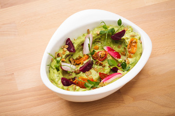 Organic plant based hummus with granola tomato, fresh thymes and rose leaf toppings. Perfect for vegan gluten free. Food photography.