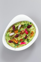 Organic plant based hummus with granola tomato, fresh thymes and rose leaf toppings. Perfect for vegan gluten free. Food photography.
