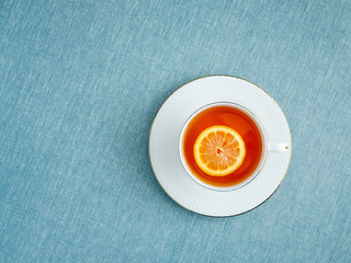 porcelain cup of hot tea on blue background with free space