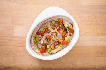 Organic plant based hummus with granola dried tomatoes toppings. Perfect for vegan gluten free. Freshly homemade for takeaway and delivery. Healthy food photography.