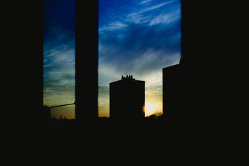 Sunset view from the window of a building, warm and melancholic atmosphere with cloud background.