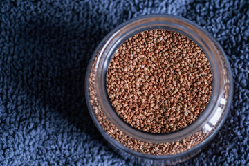 Color and bright photo of a big can with buckwheat and an open lid on a blue background with empty place for concept and text. Saving food in a pandemic