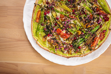 Delicious fresh homemade manakish with asparagus, dried tomatoes, quinoa and spring onions. Perfect for vegetarian. Healthy food photography concept.