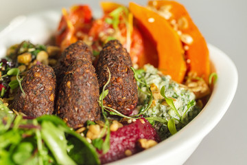 Delicious healthy salad with falafel and dried tomatoes. For healthy living. Perfect for takeaway and delivery. Vegan food photography focus view.