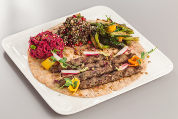 Delicious homemade kebab with salad side dish. beetroot, asparagus, and quinoa. Organic food photography takeaway and delivery concept.
