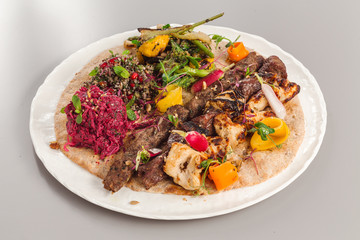 Delicious homemade kebab and chicken tikka salad side dish. beetroot, asparagus, and quinoa. Organic food photography.