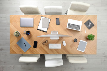 Modern office table with devices and chairs, top view