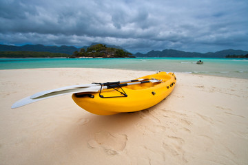 Yellow boat on the secluded beach in the tropical island, travel concept