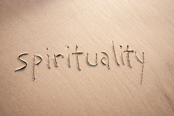 Simple non-denominational spirituality message handwritten in lowercase letters on textured sand beach