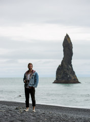 photographer standing on black sand beach in iceland