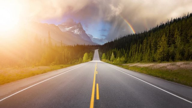 Cinemagraph Continuous Loop Animation. Scenic road in the Canadian Rockies during a vibrant sunny summer sunrise. Sky with Sunrays. Taken in Icefields Parkway, Banff National Park, Alberta, Canada.