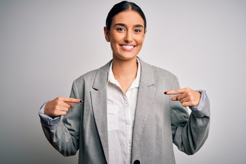 Young beautiful brunette businesswoman wearing jacket standing over white background looking...