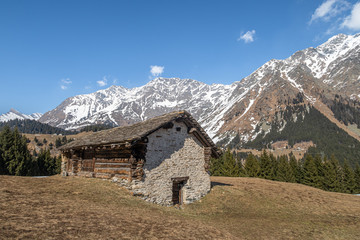 Fototapeta na wymiar SAN BERNARDINO, SWITZERLAND - APRIL 2, 2020: A shepherd's cottage under the village of San Bernardino, surrounded by the Alps