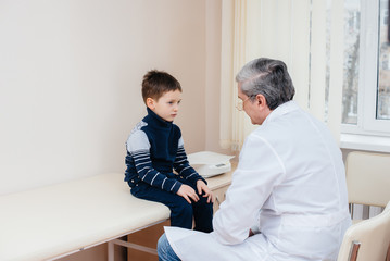 A young boy is listened to and treated by an experienced doctor in a modern clinic. A virus, and an epidemic