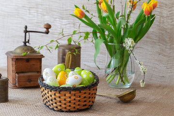 Beautiful Easter decoration - hen, faucet with Easter eggs and nice flowers. Photo on a light background.