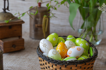 Beautiful Easter decoration - hen, faucet with Easter eggs and nice flowers. Photo on a light background.