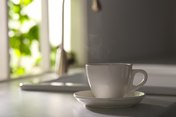 Cup of delicious coffee on kitchen countertop, space for text. Good morning