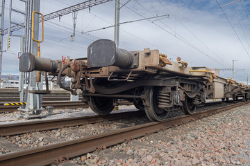 Fototapeta na wymiar LUPFIG, SWITZERLAND - MARCH 8, 2020: Rusty empty railway chassis-wagon for transporting vehicles on the railway track at Lupfig