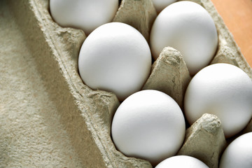 White chicken eggs in a cardboard box on the side view. Agricultural useful food products