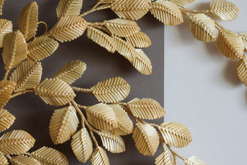 Fototapeta na wymiar The branch with leaves is made of straw. Straw wall decoration. The products are made of straw. Decoration of straw on a gray white background