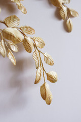 Decoration of straw on a white background. Branch with leaves is made of straw. Decor. Fragment closeup