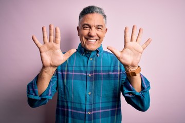 Middle age handsome grey-haired man wearing casual shirt over isolated pink background showing and...
