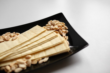 long potato chips, roasted peeled peanuts, salted beer snacks in black plate