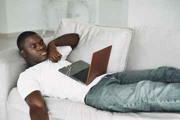 man relaxing on sofa with laptop