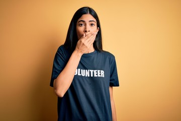 Young beautiful hispanic woman wearing volunteer t-shirt as social charity moral shocked covering...