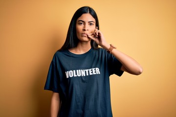 Young beautiful hispanic woman wearing volunteer t-shirt as social charity moral mouth and lips...