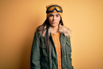 Young beautiful hispanic woman wearing ski glasses and coat for winter weather skeptic and nervous, frowning upset because of problem. Negative person.